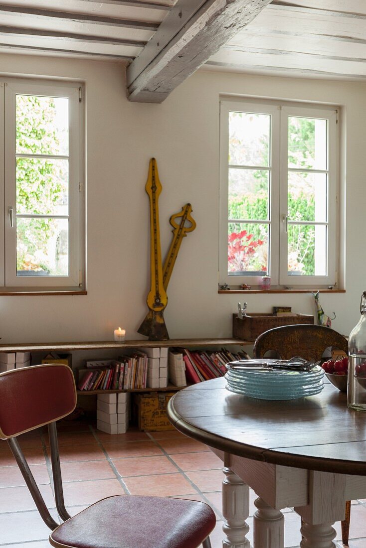 Essplatz mit Retrostuhl, im Hintergrund große Vintage Uhrzeiger auf Ablage in rustikalem Landhaus Ambiente