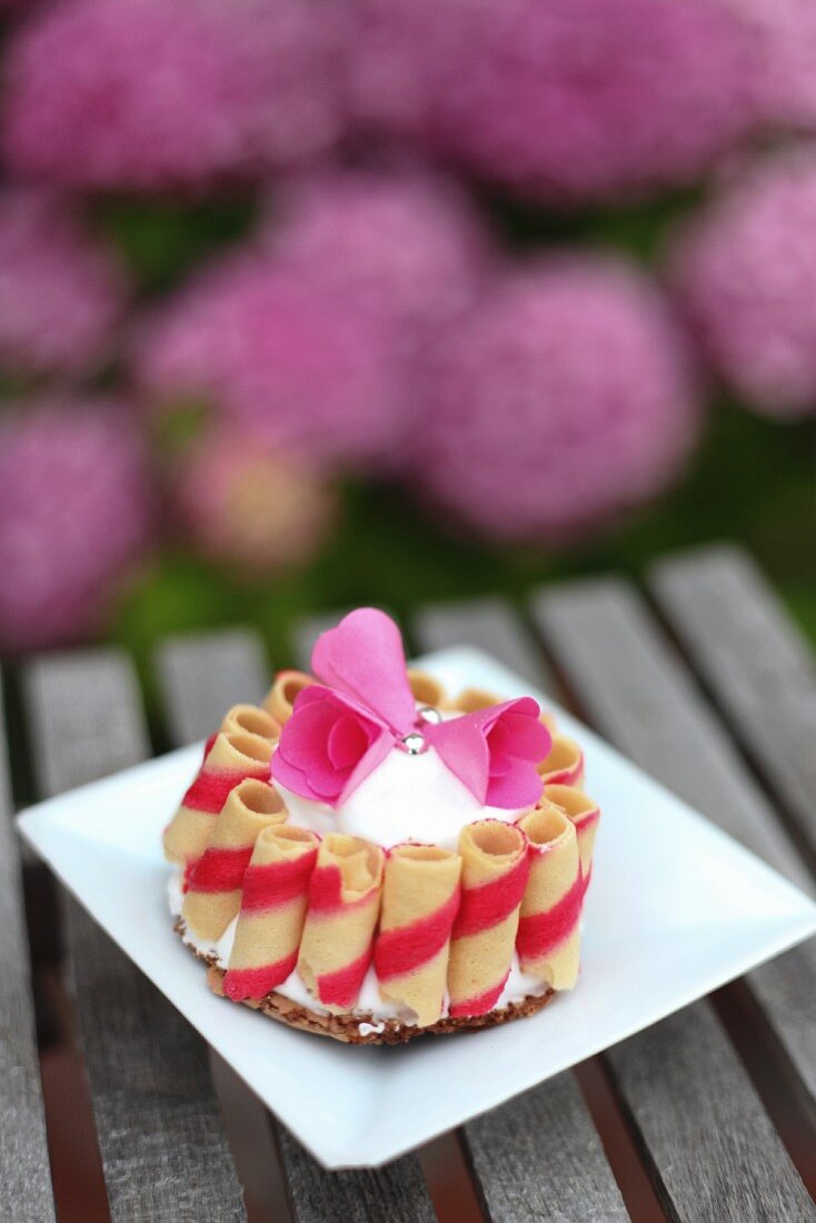 A mini cake decorated with wafer rolls