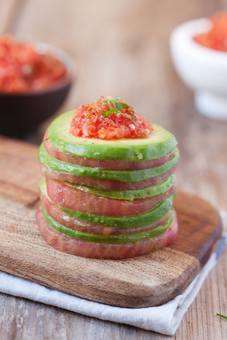 A tomato and avocado towers with a spicy chilli sauce