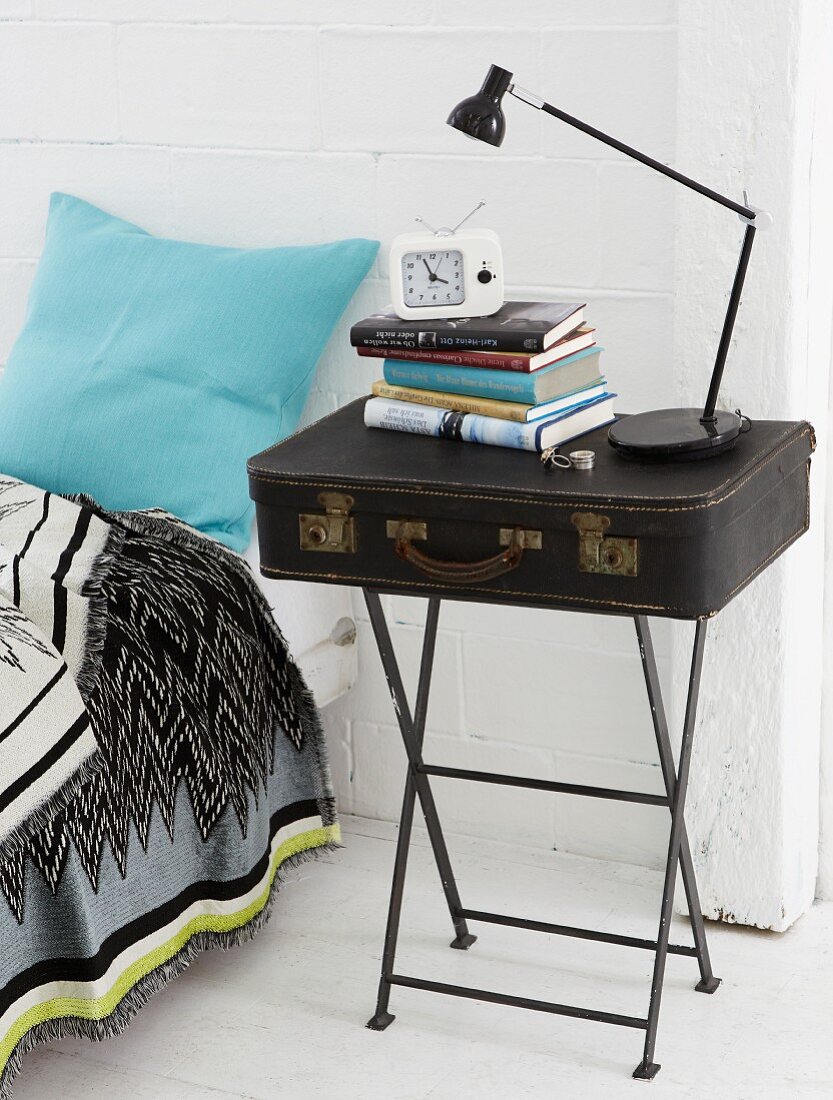 A homemade bedside table – a suitcase on a vintage-style metal side table