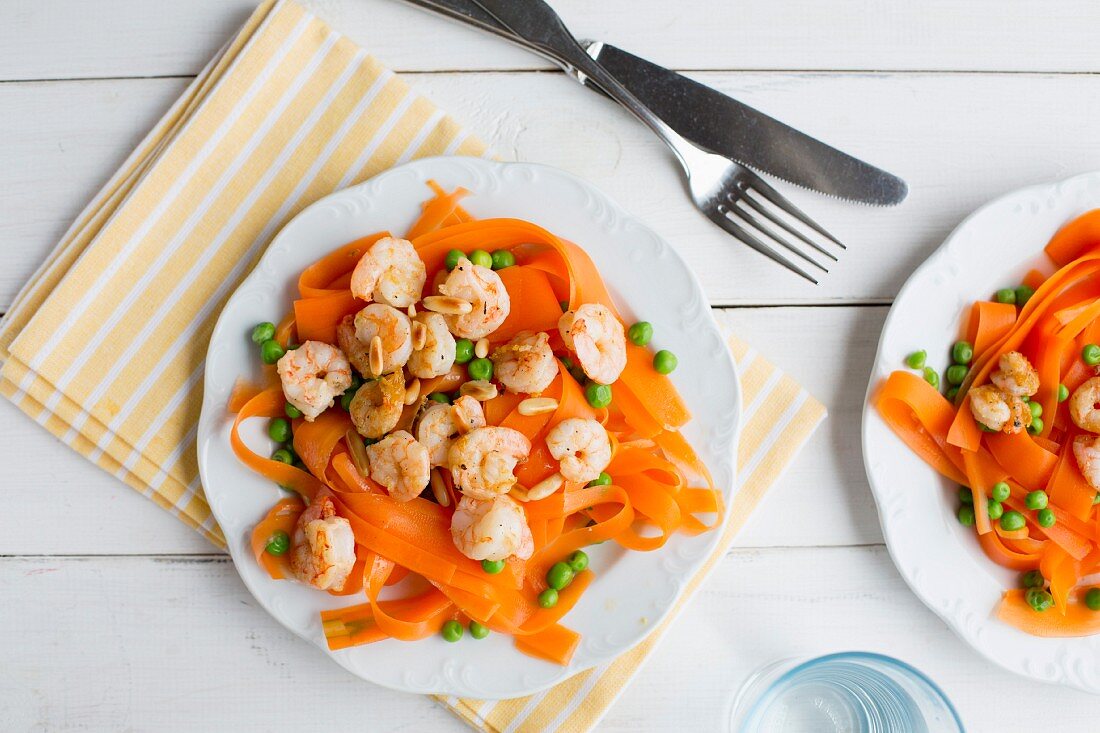 Carrot tagliatelle with prawns, peas and pine nuts