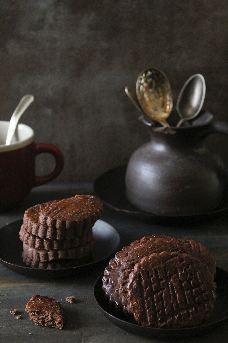 A stack of chocolate biscuits and a jug of cutlery