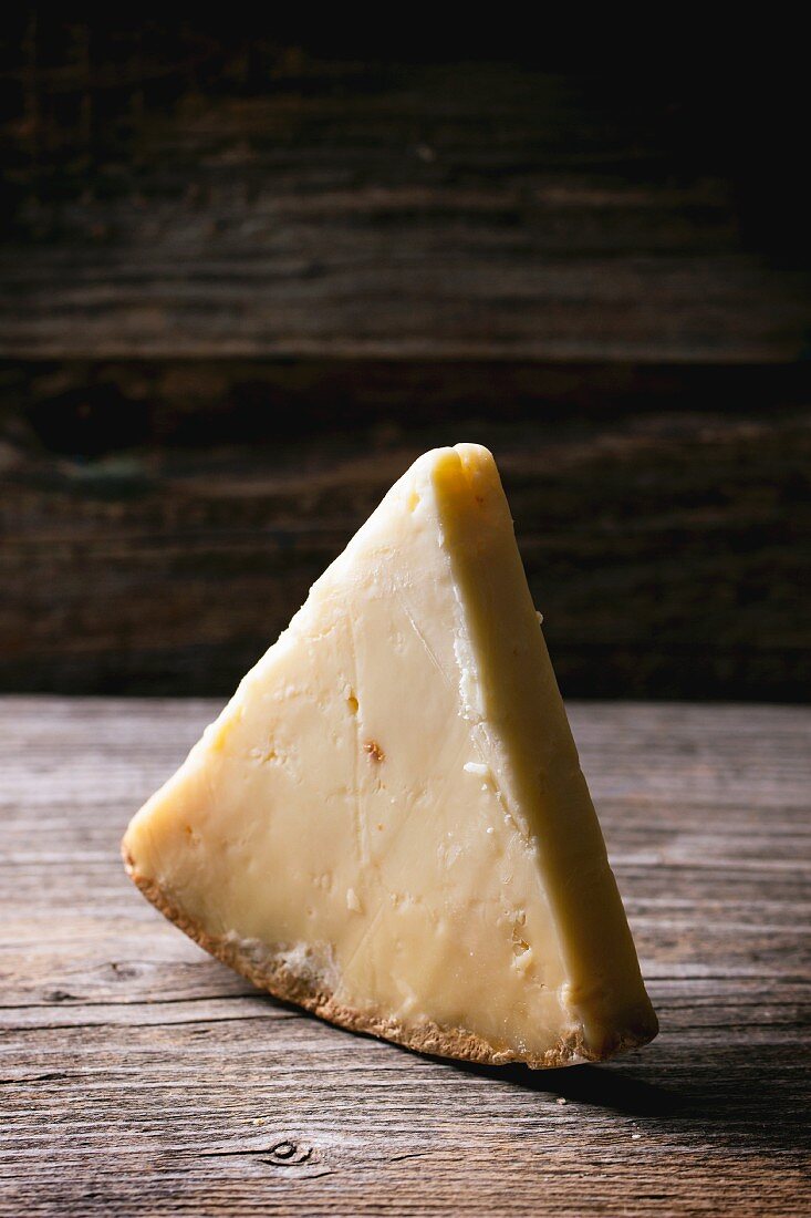 A piece of Belgian cheese on a wooden table