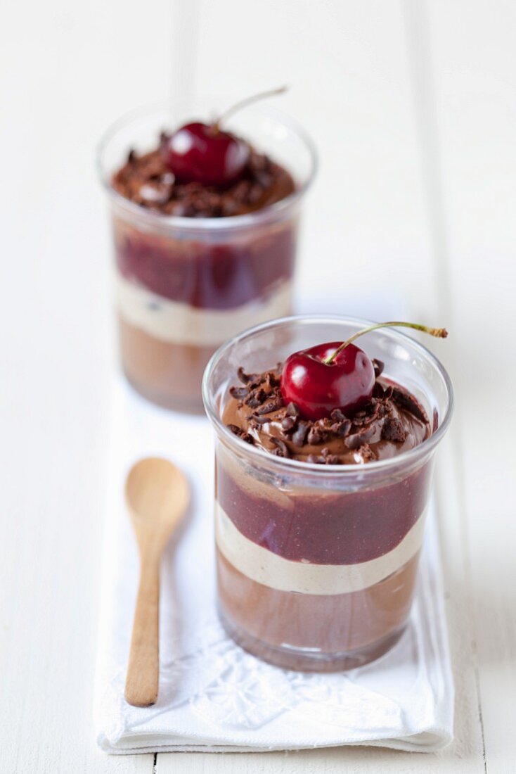 Chocolate layered desserts with cherry jam and fresh cherries
