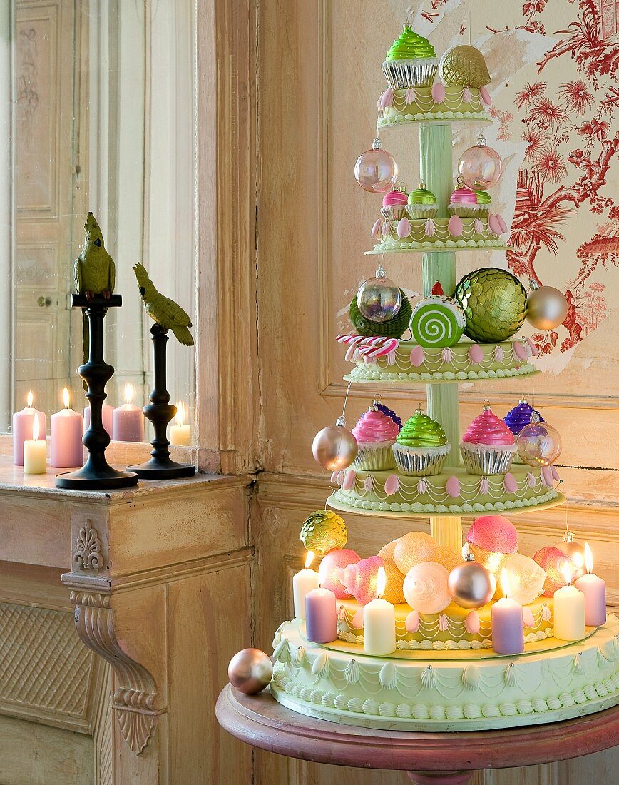 Christmas arrangement of baubles and candles on cake stand