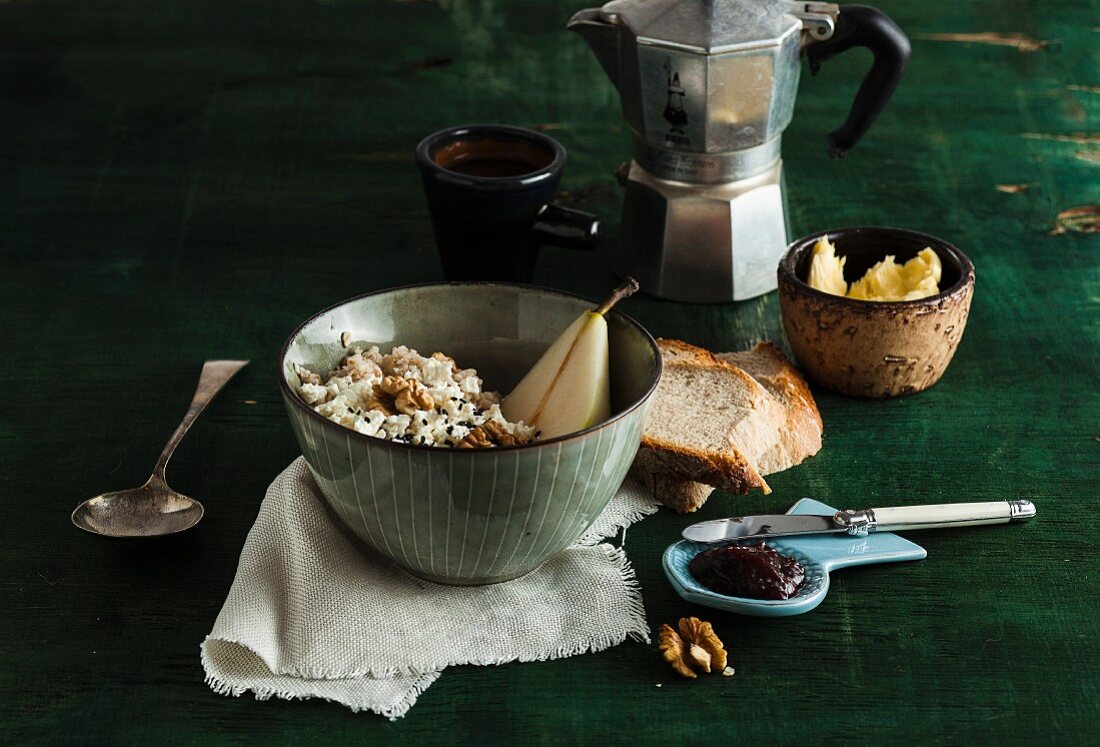 Frühstücksmüsli mit Birnen und Walnüssen, Brot, Marmelade und Kaffee