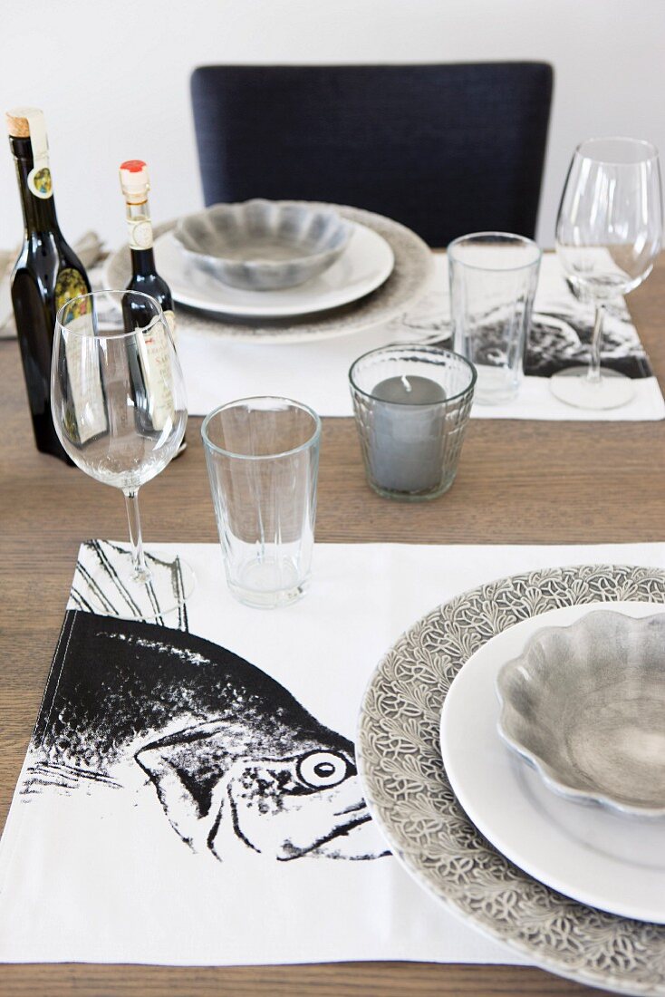 White and grey place setting with fish motif on place mat