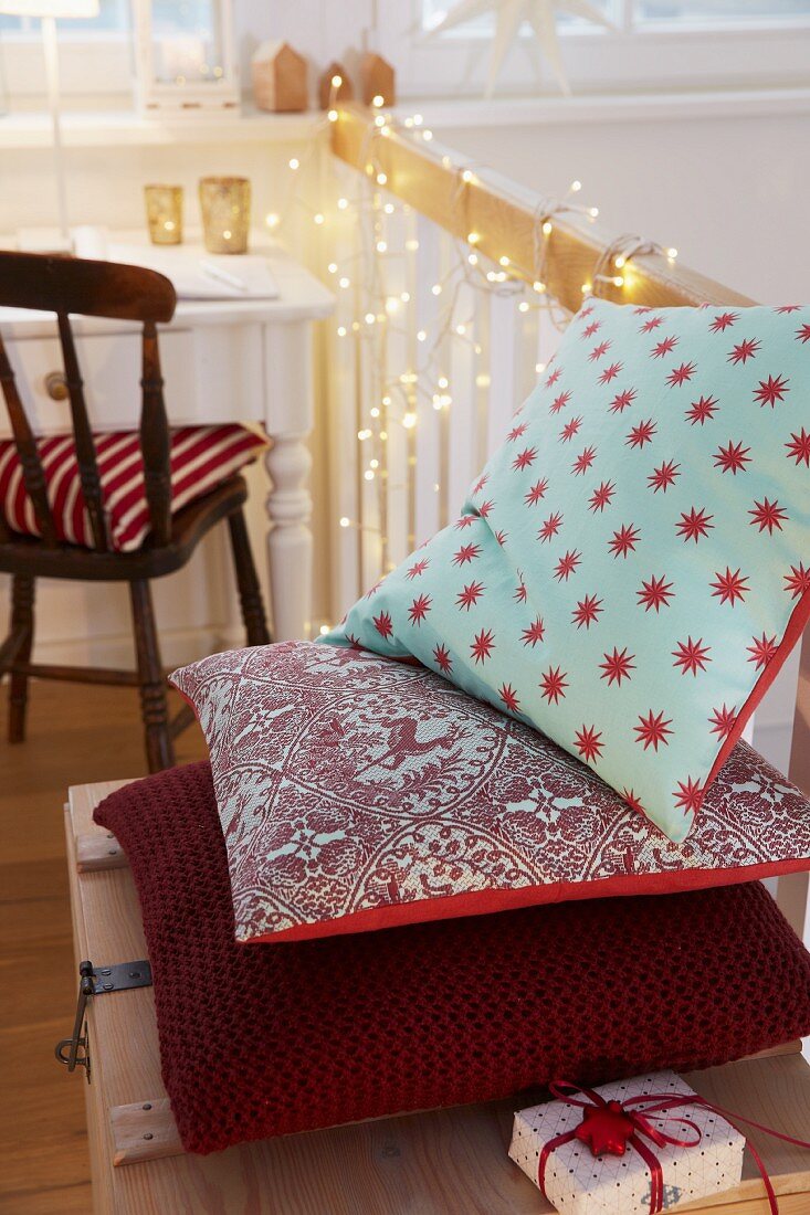 A homemade cushion cover with Christmas patterns and a coarse knitted cushion in Burgundy red