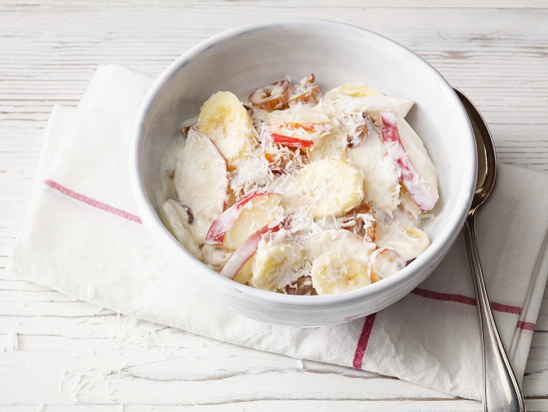 Yoghurt with pears, banana, dried dates and coconut flakes