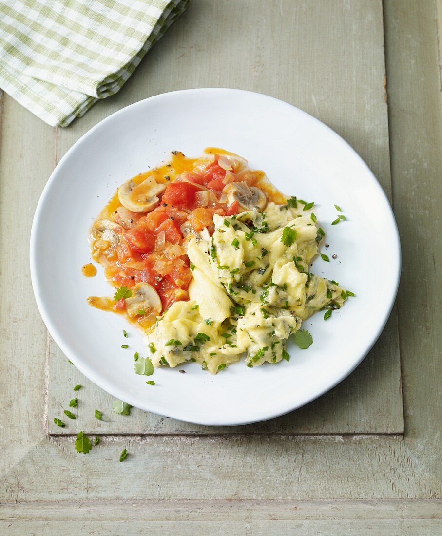 Herb scrambled eggs with fried tomatoes and mushrooms for an alkaline diet