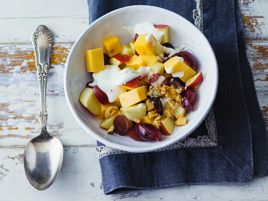 Cheese and fruit salad with chopped walnuts and sour cream