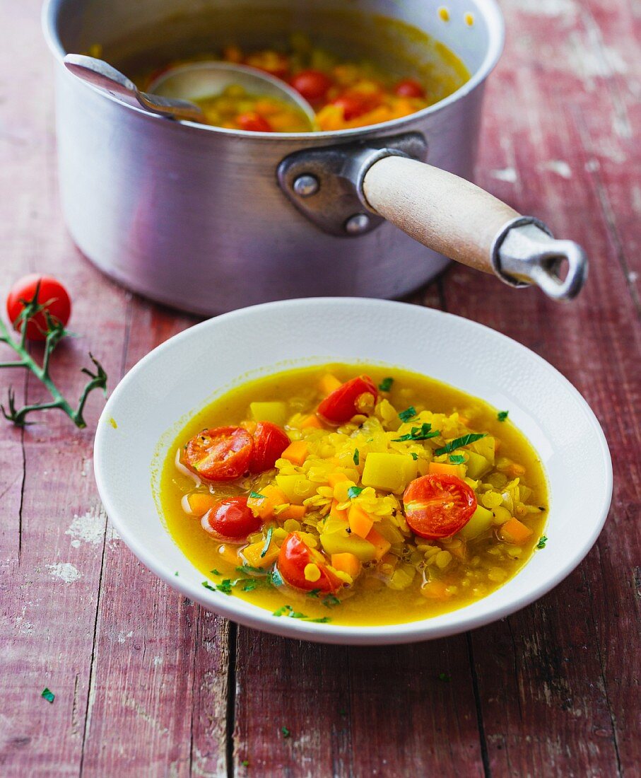 Indian vegetable soup made from yellow lentils, carrots, cherry tomatoes and turmeric