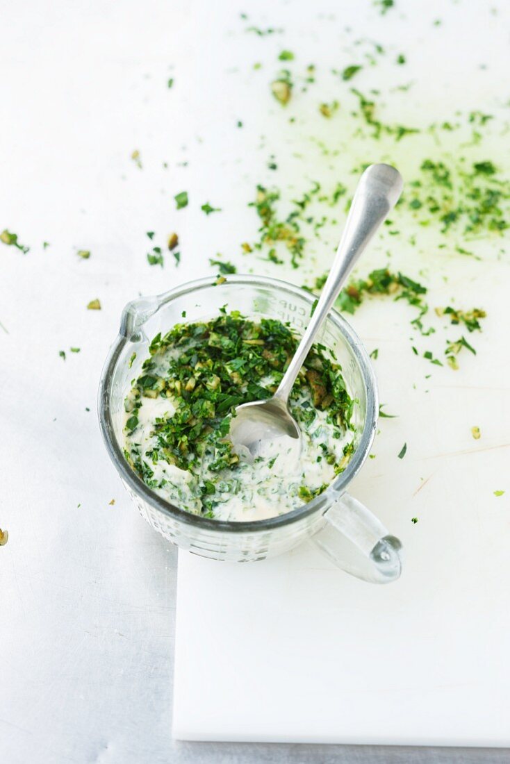 Cucumbers and herbs being mixed with mayonnaise