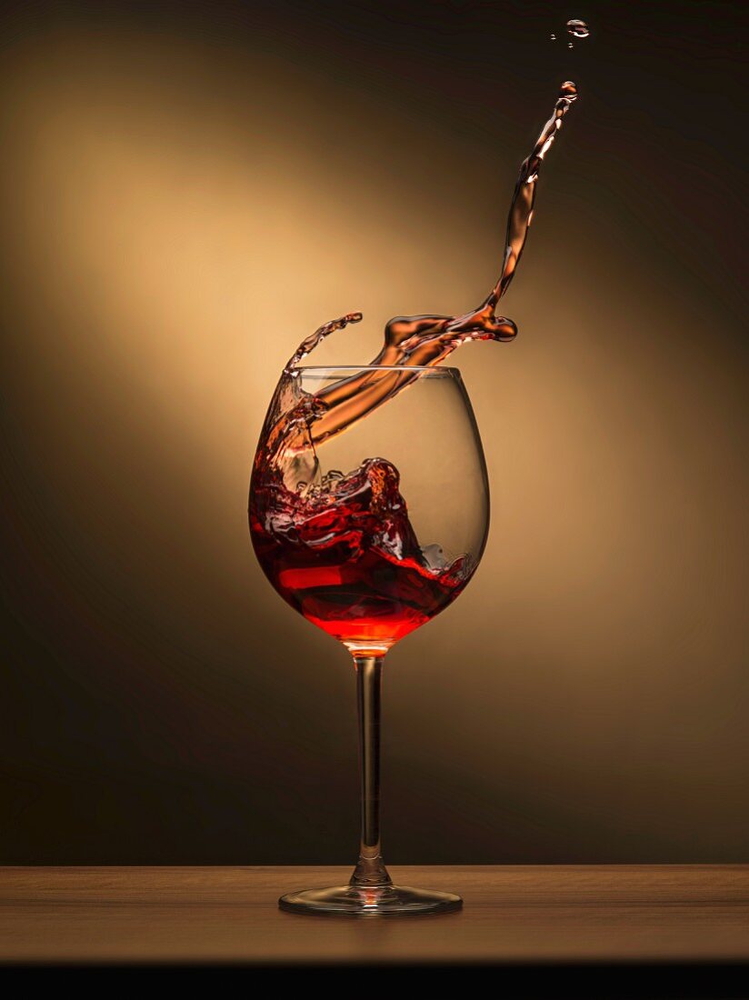 Red wine splashing out of a glass