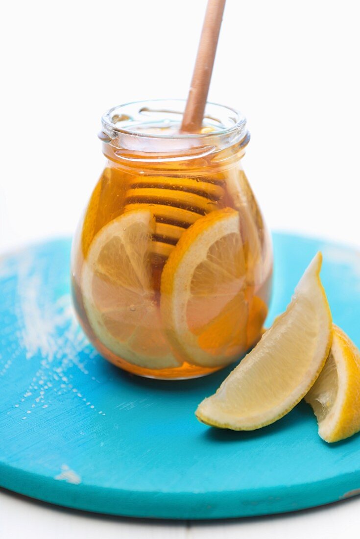 A jar of honey with lemon slices