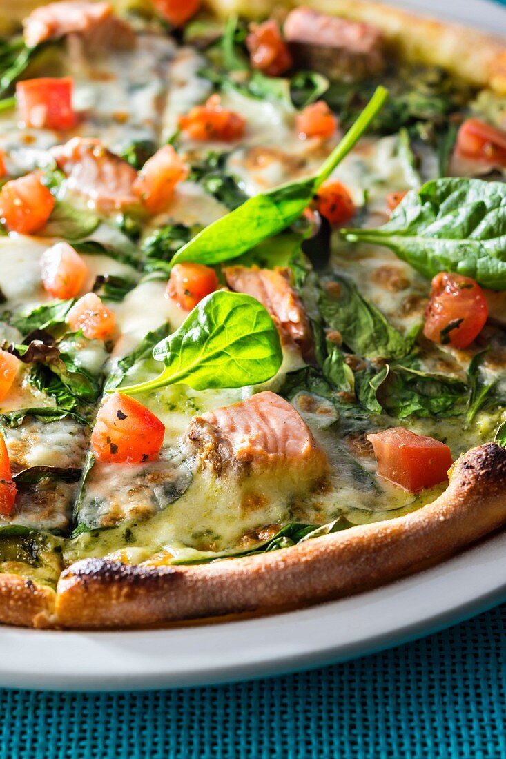Pizza with salmon, spinach and tomato