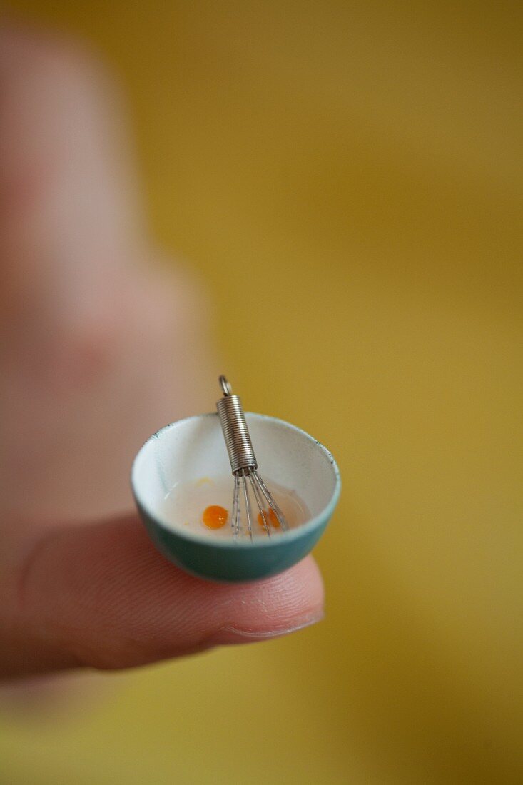 A tiny bowl of beaten eggs on a fingertip