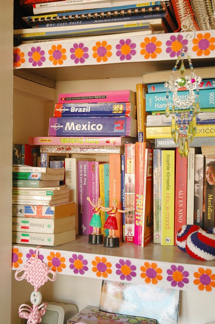 Detail of bookcase with bright, 70s floral trim on shelf edges