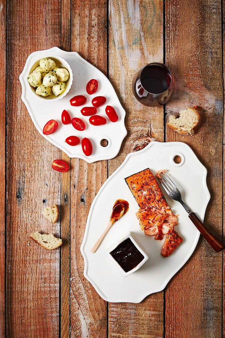 Antipastiplatten mit Lachs, Tomaten, Artischocken, Brot und Rotwein