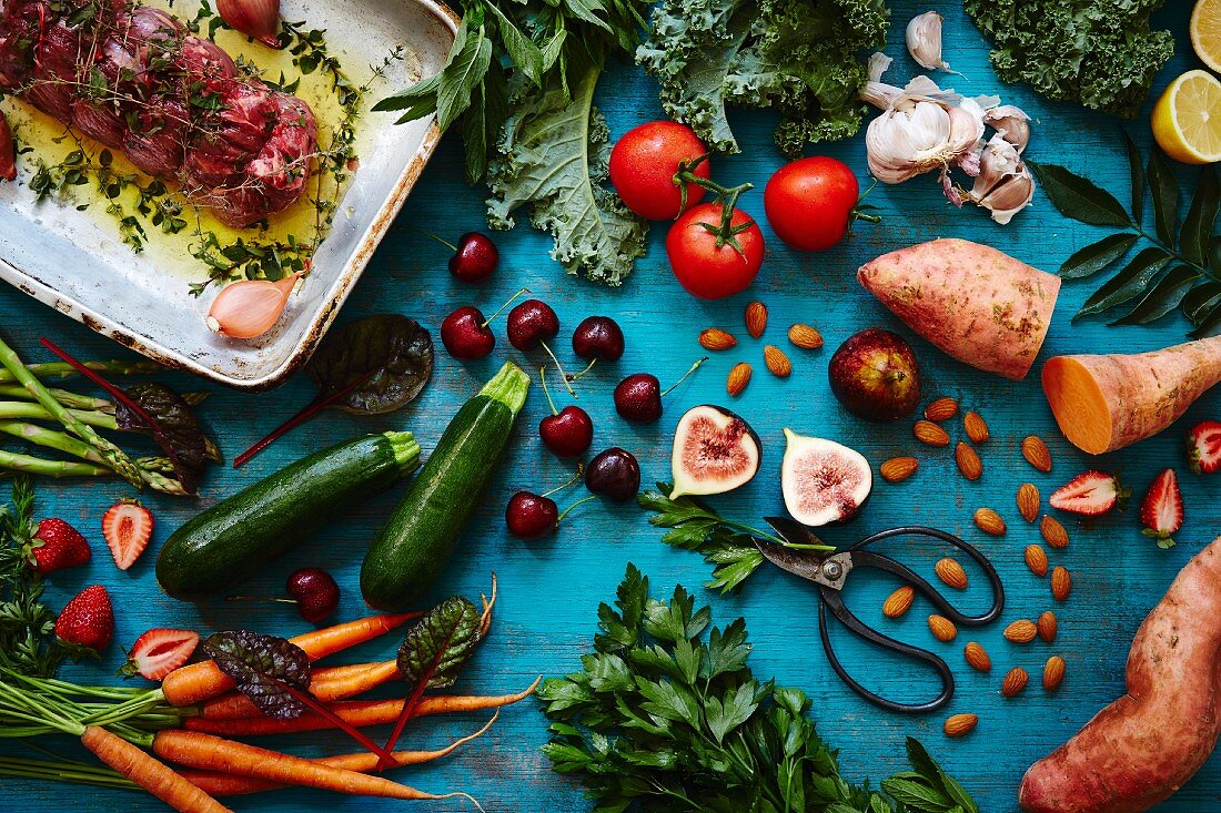 An arrangement of vegetables, fruit, almonds, herbs and lamb