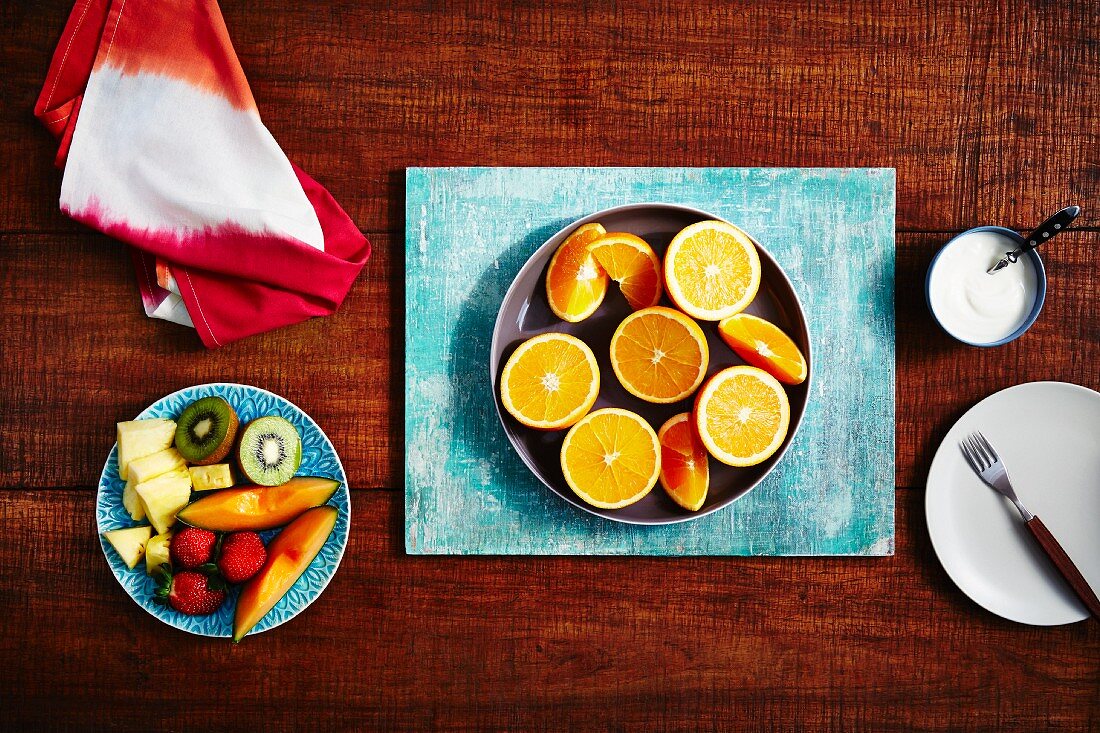 Orangen (halbiert, Schnitze) und frischer Obstsalat