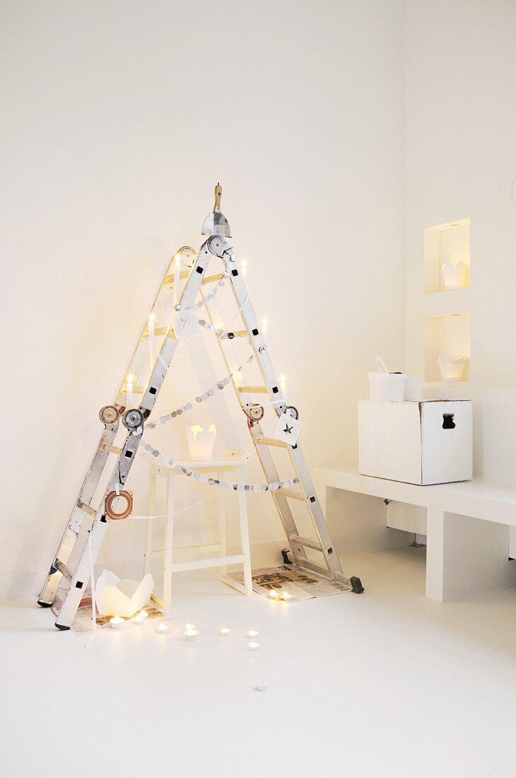 Alternative Christmas tree made from folding ladder and take-away cartons used as candle lanterns