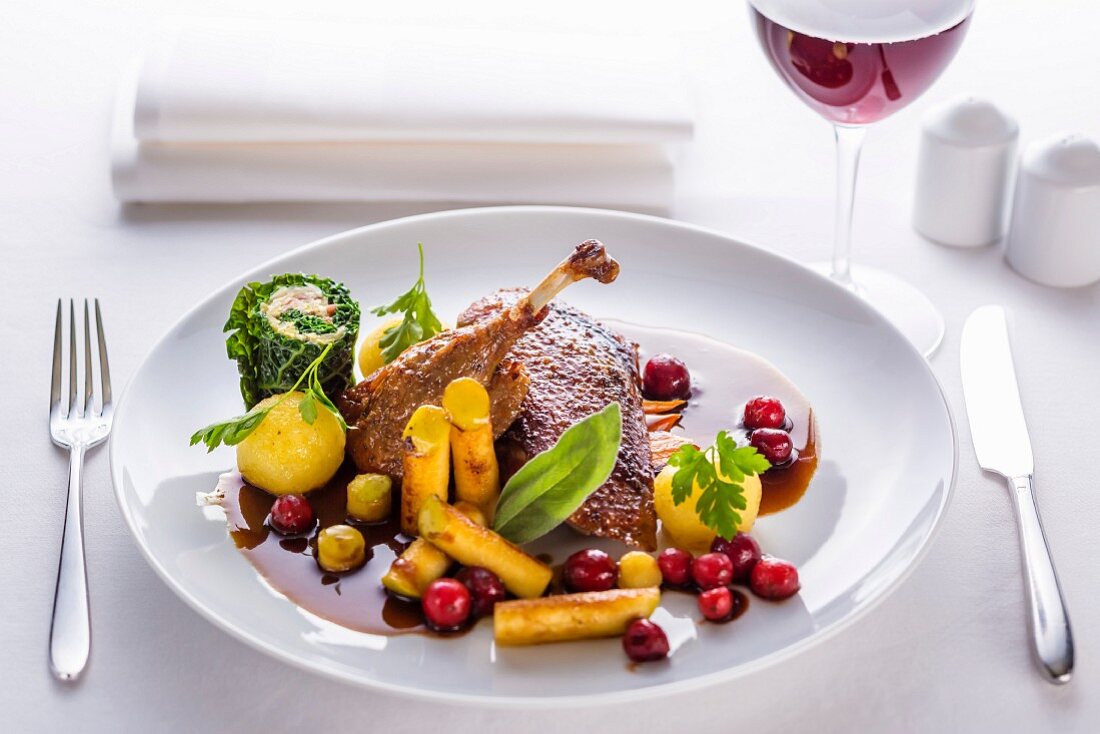 Duck with a honey glaze and sauce served with berries, black salsify and savoy cabbage