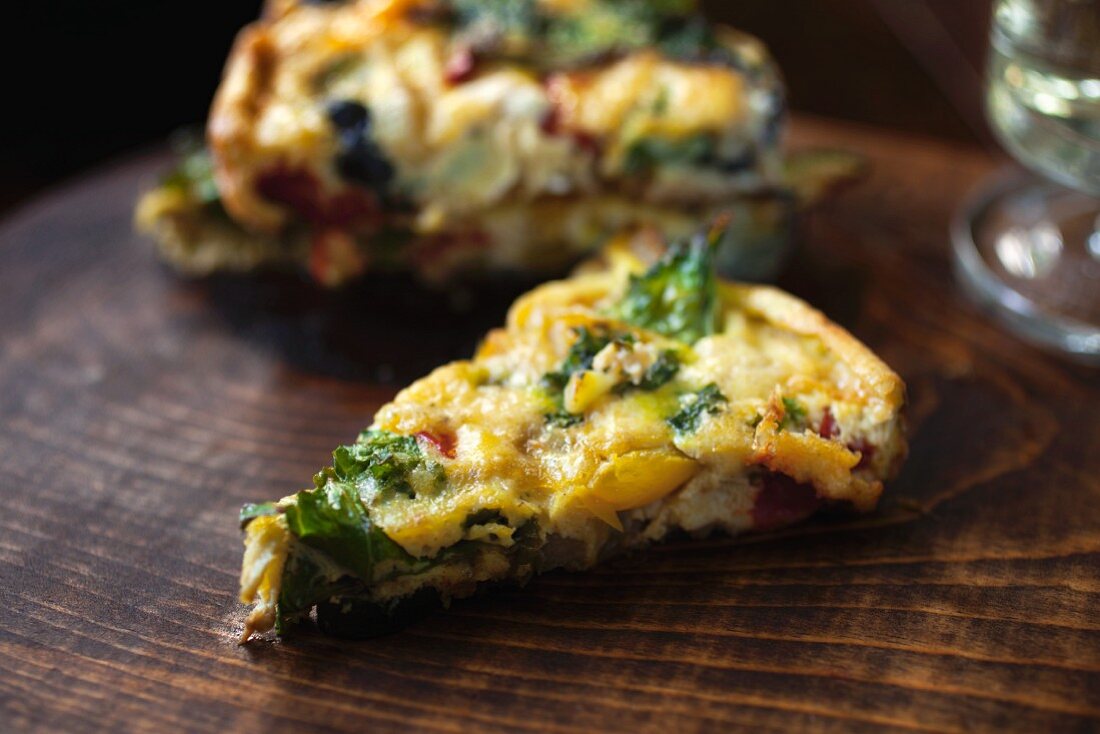 Vegetable fritatta on a wooden board (close-up)