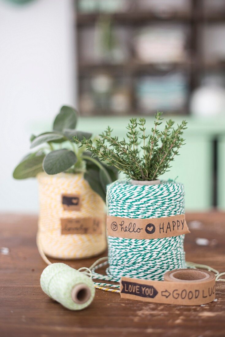 A roll of twine decorated with a bunch of fresh herbs and sticky tape