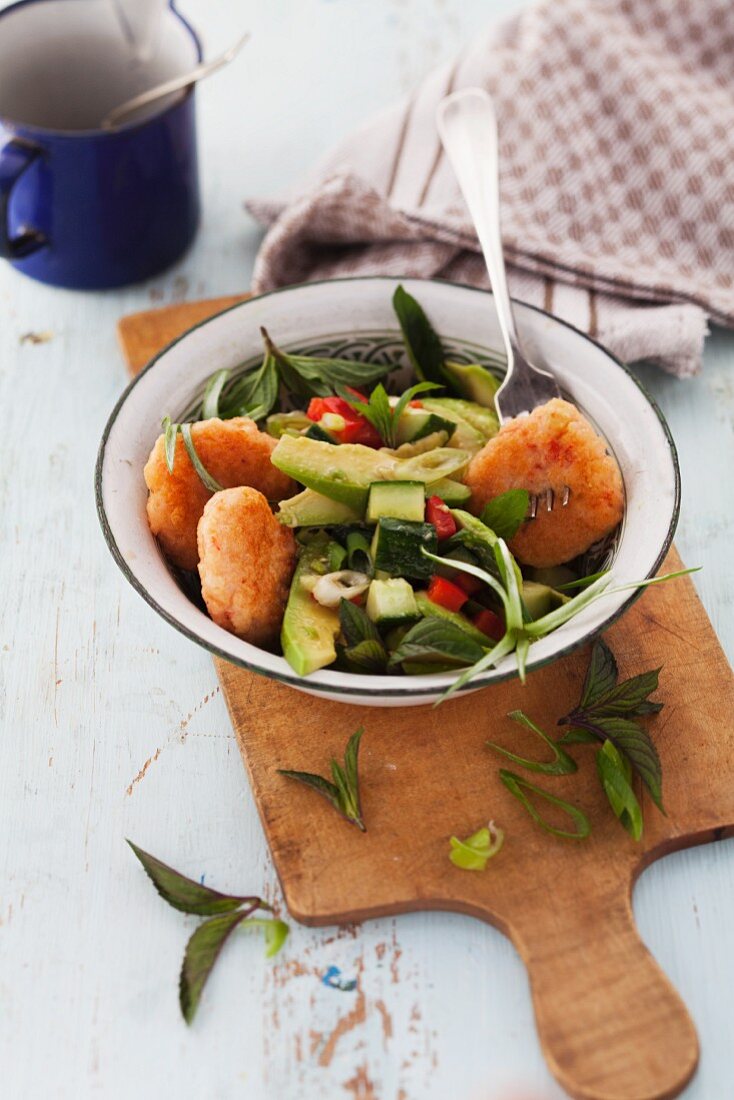 Prawn cakes with an avocado and cucumber salad