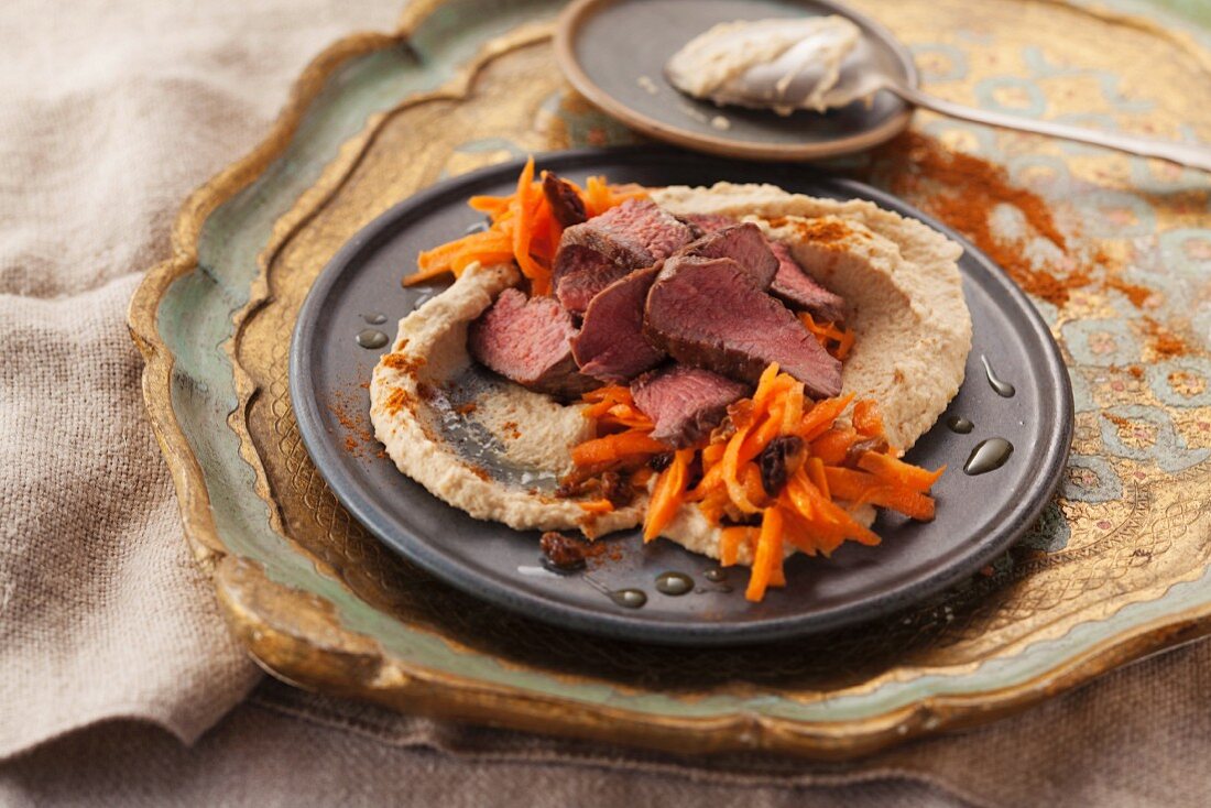 Fried lamb fillets with a carrot salad and hummus