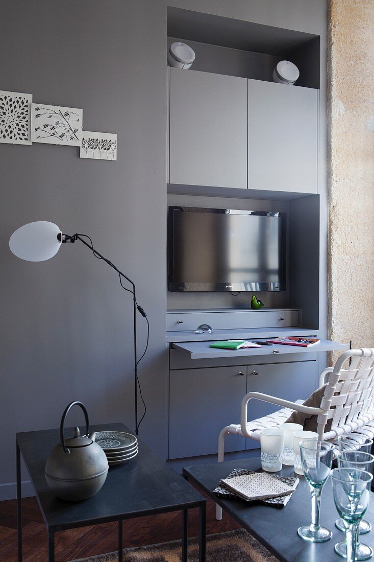 Fitted cupboards in niche with pull-out desk and TV