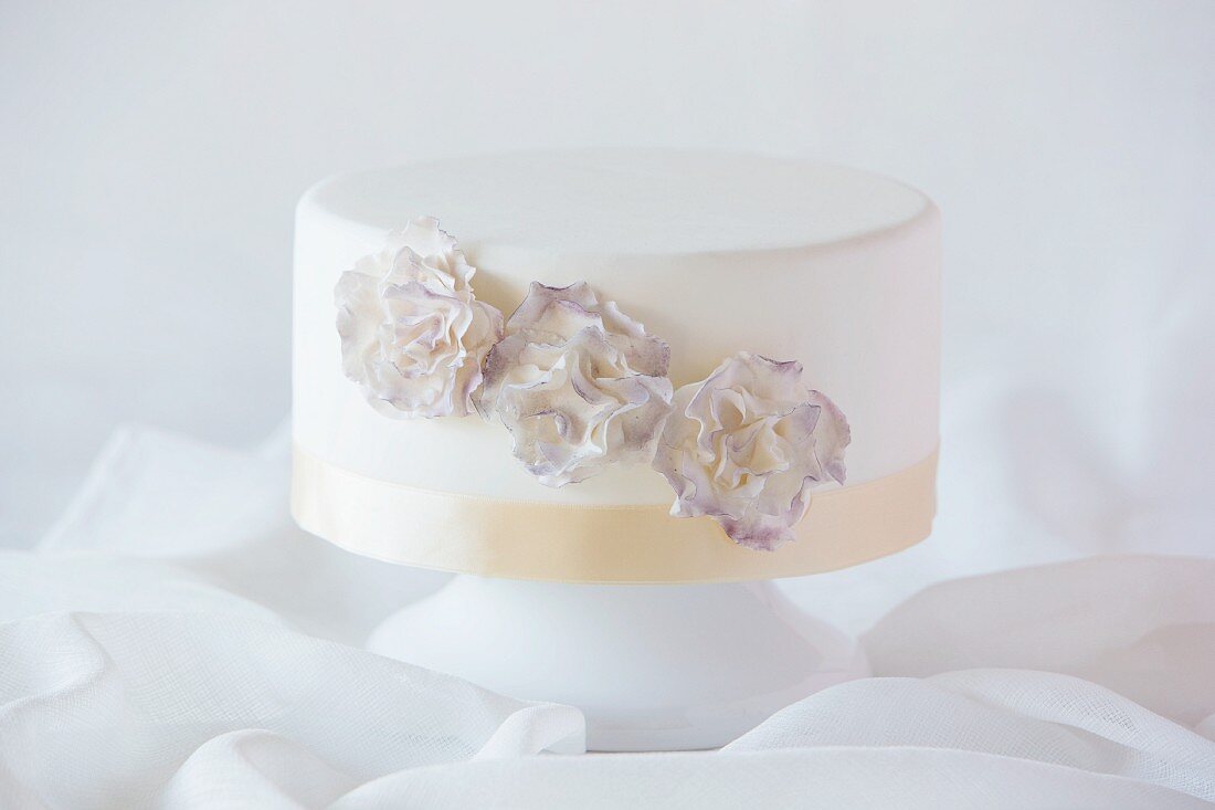 A white wedding cake decorated with flowers