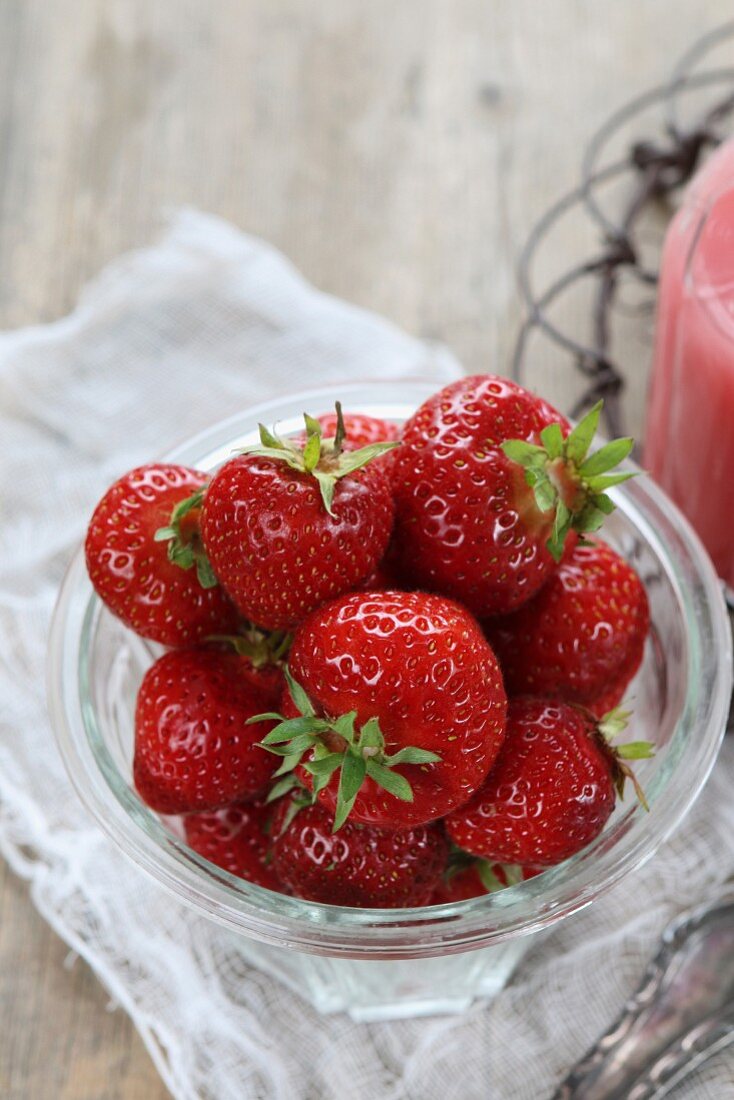 Fresh strawberries in a jar with a homemade strawberry milkshake
