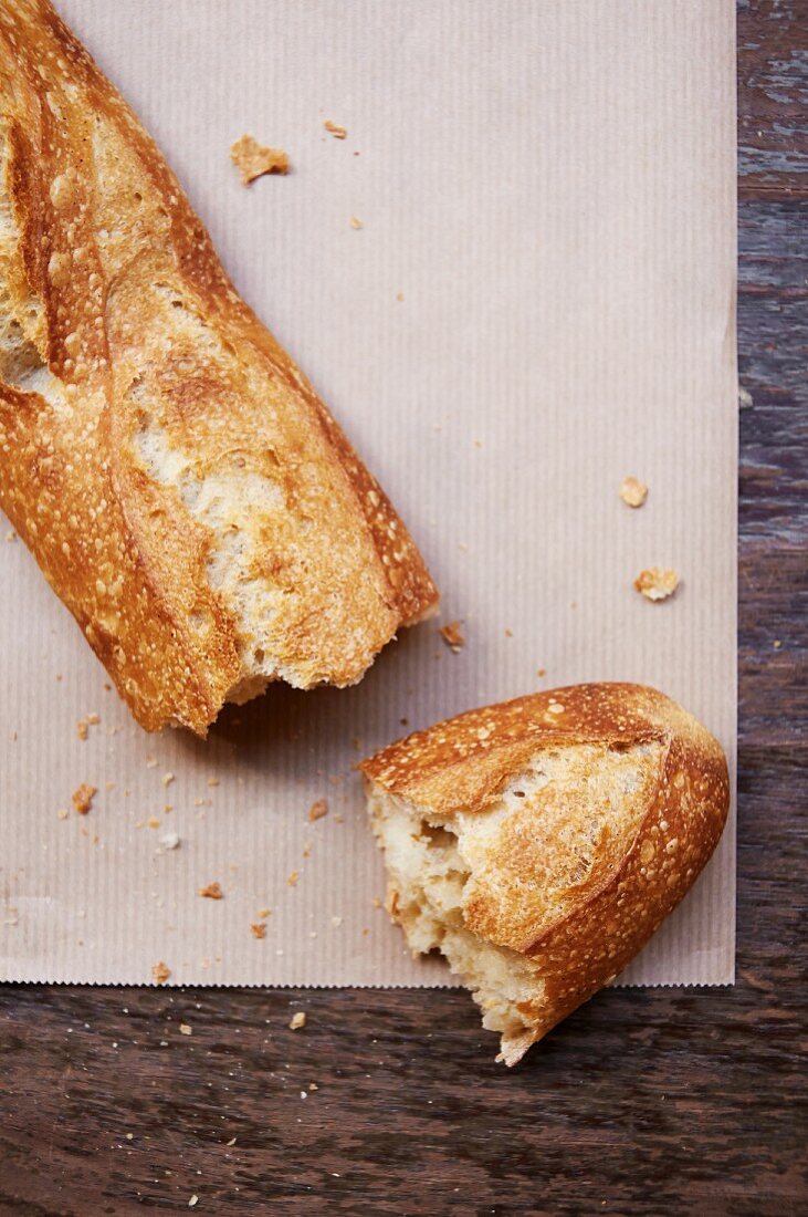 A broken baguette on a piece of paper