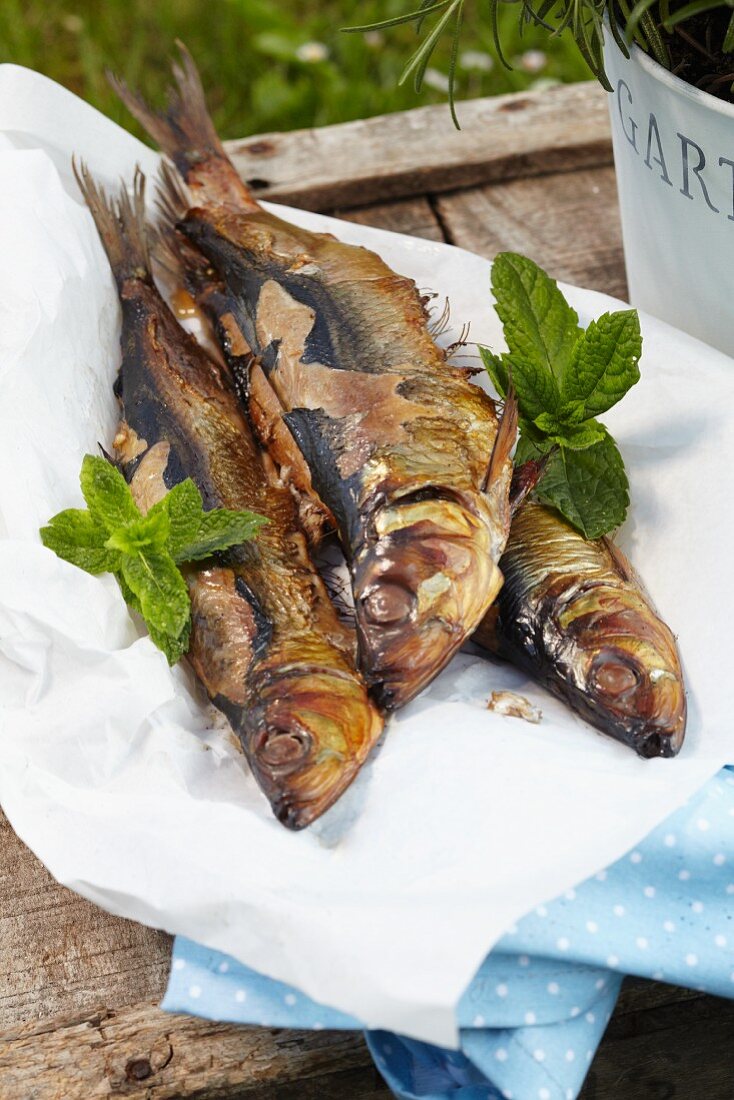 Grilled herring on a wooden crate