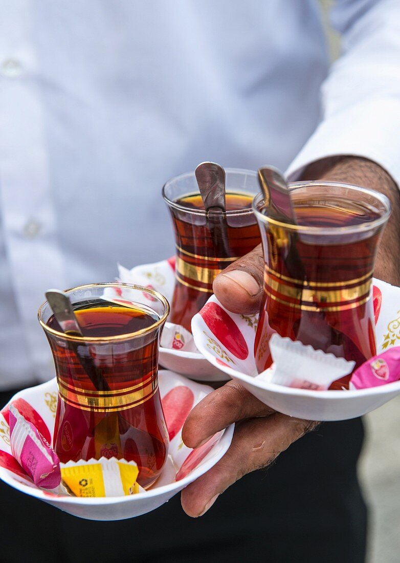 Three glasses of Turkish tea being served