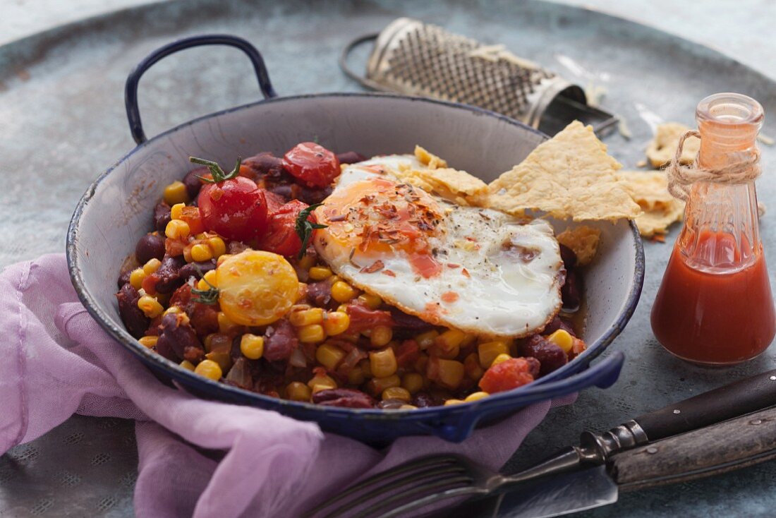 A fried egg on kidney bean and sweet corn hash (Tex-Mex)