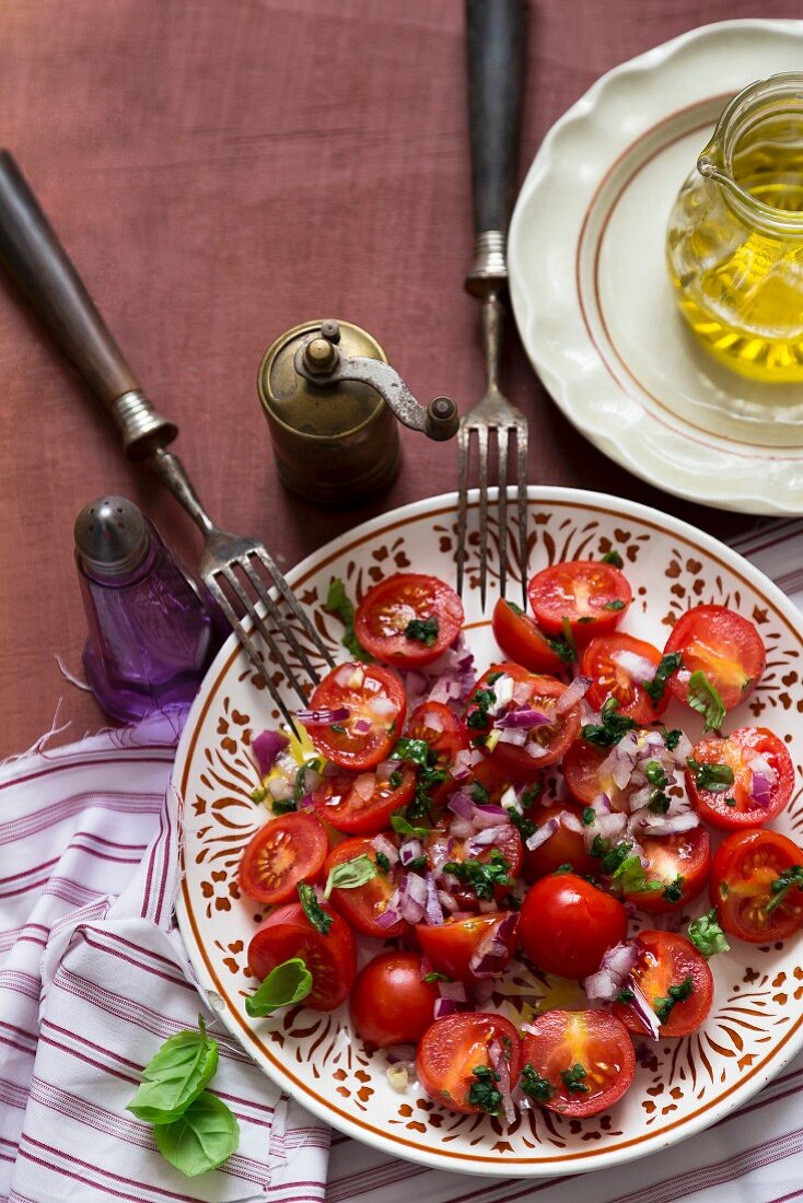 Salat aus Cocktailtomaten mit roten Zwiebeln und Basilikum