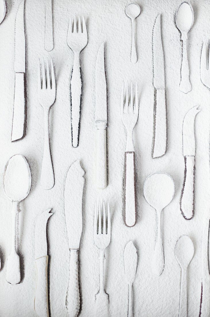 Various items of cutlery dusted with flour (seen from above)