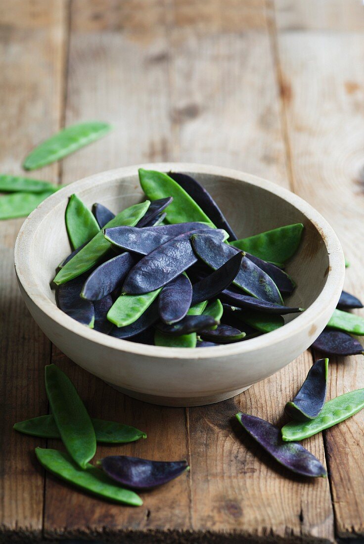 A bowl of green and purple mange tout