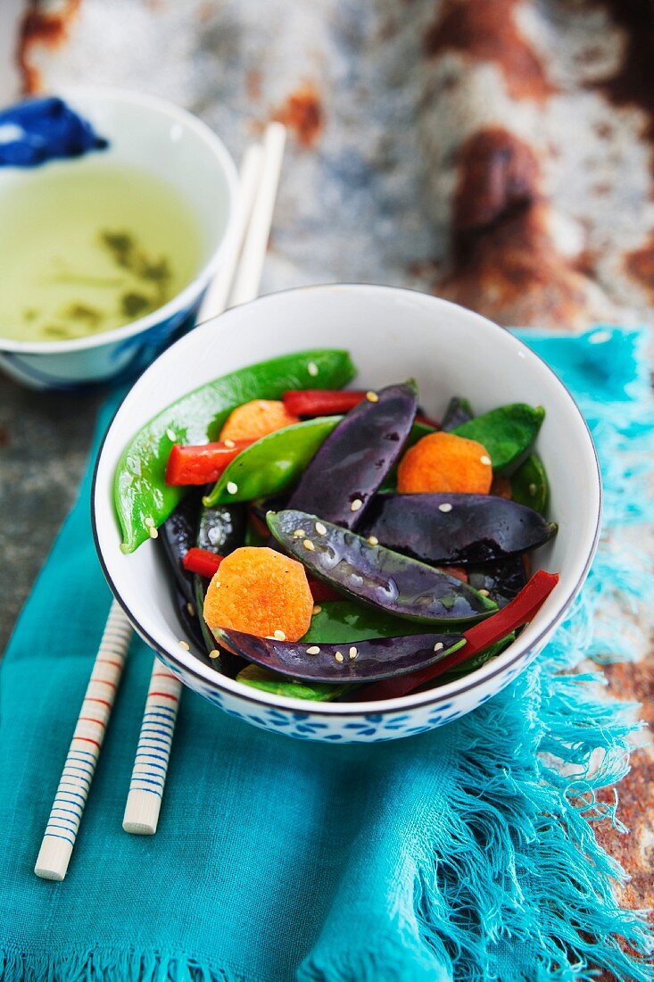 Pfannengebratene violette & grüne Zuckerschoten mit Karotten und Chili