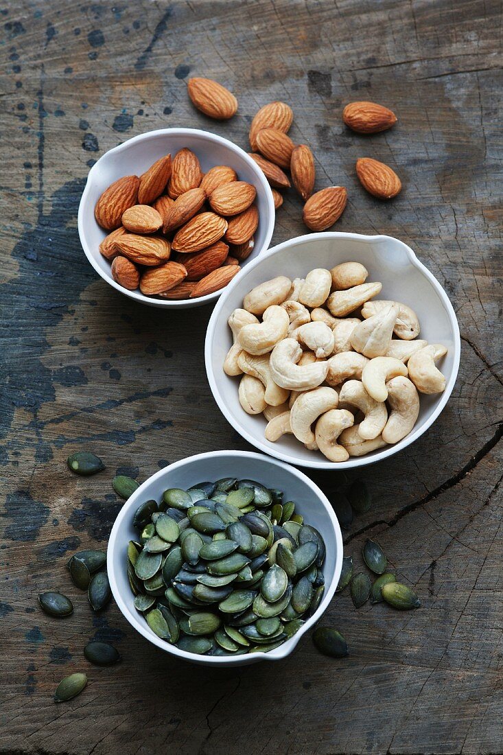 Bowls of almonds, cashew nuts and pumpkin seeds