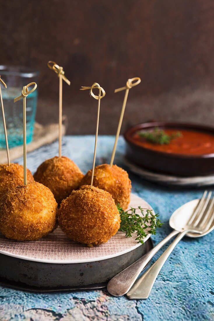 Arancini on sticks with tomato sauce