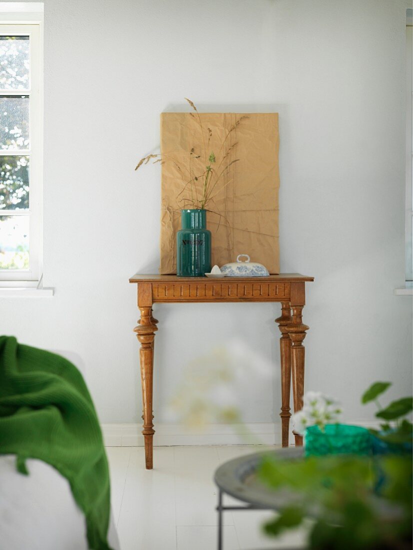 Ornamental grasses in retro vase on antique console table