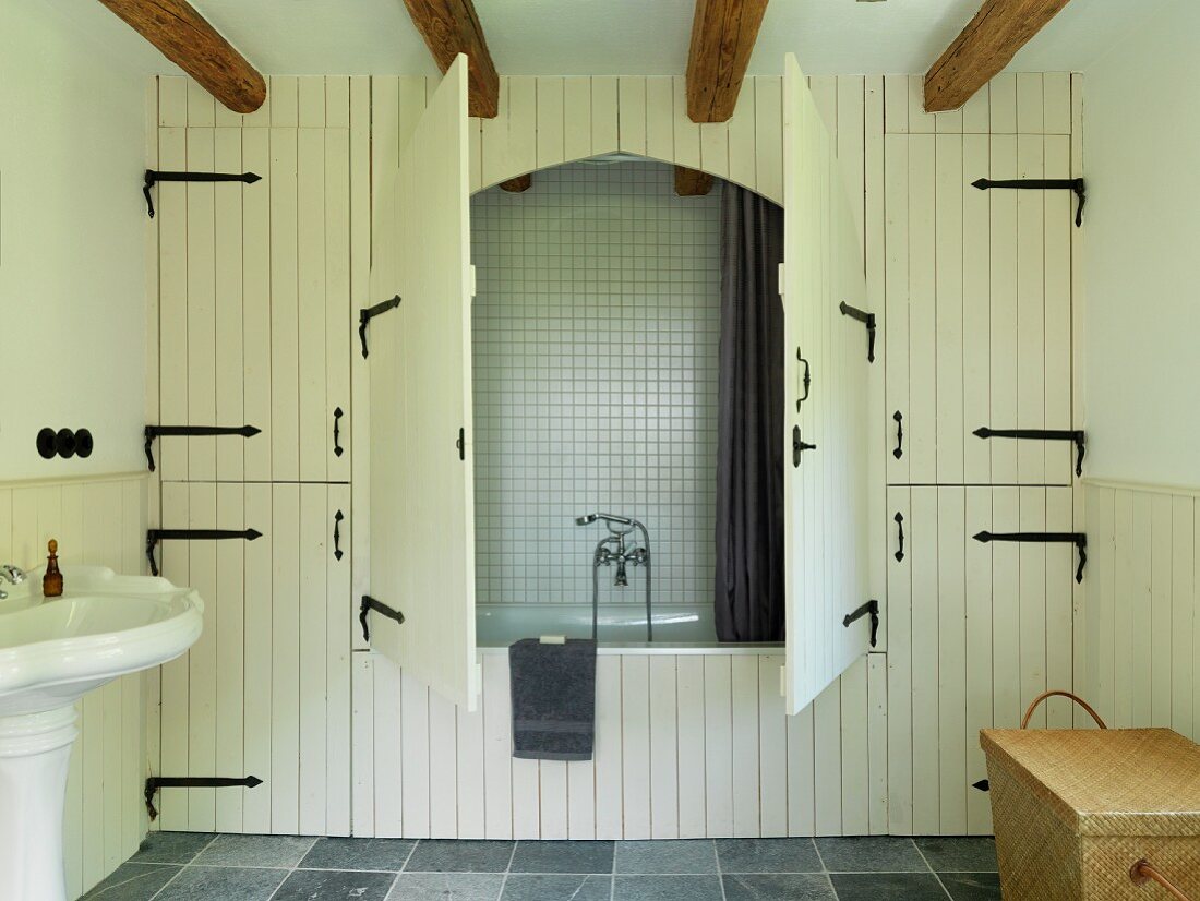 Rustic alcove bathtub integrated into fitted cupboards