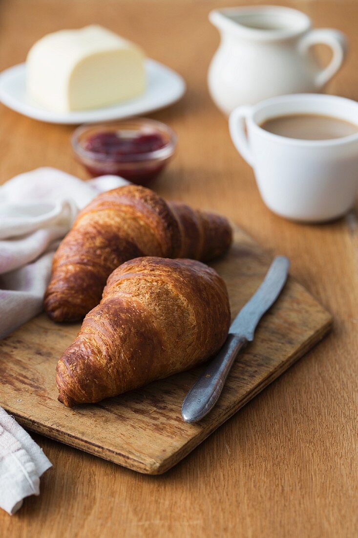 Frühstück mit Croissants, Kaffee, Butter und hausgemachter Marmelade