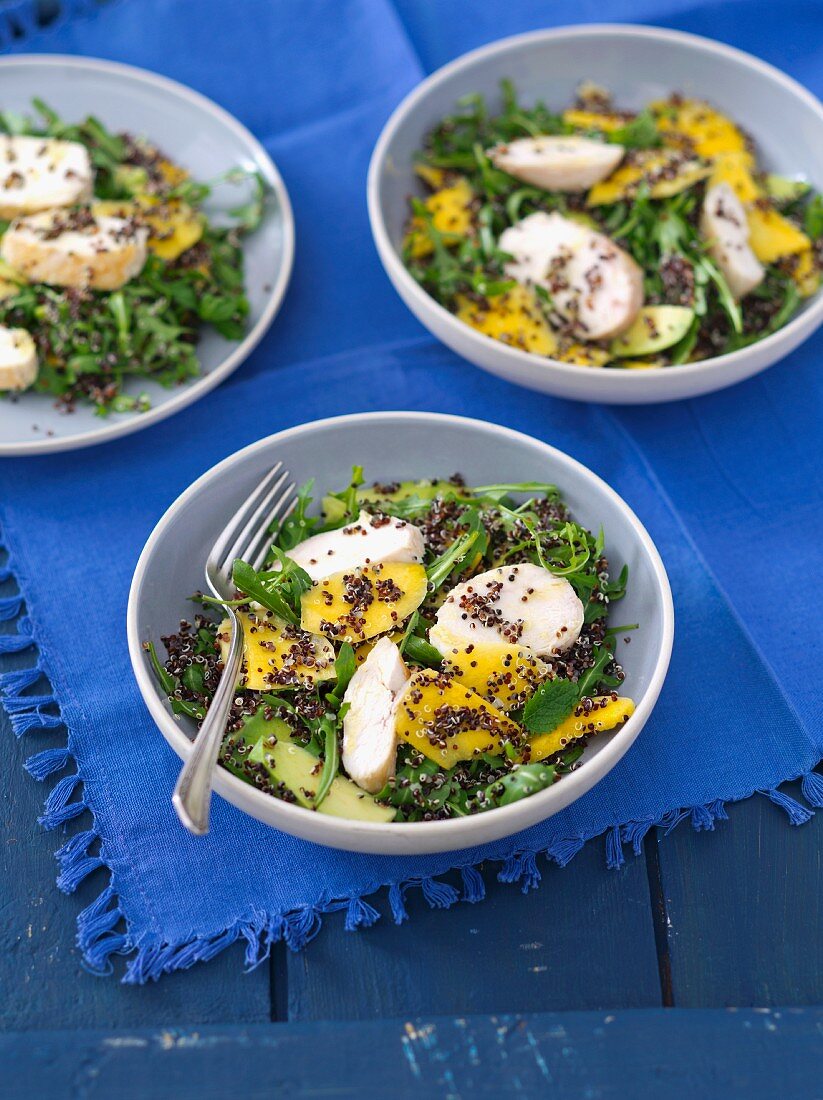 Rucolasalat mit Quinoa, Avocado, Mango und gegrillter Hähnchenbrust mit Ingwervinaigrette