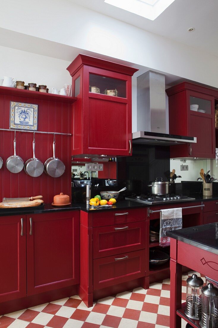 Rot lackierte Küchenschränke in Landhausküche mit Schachbrettmusterboden