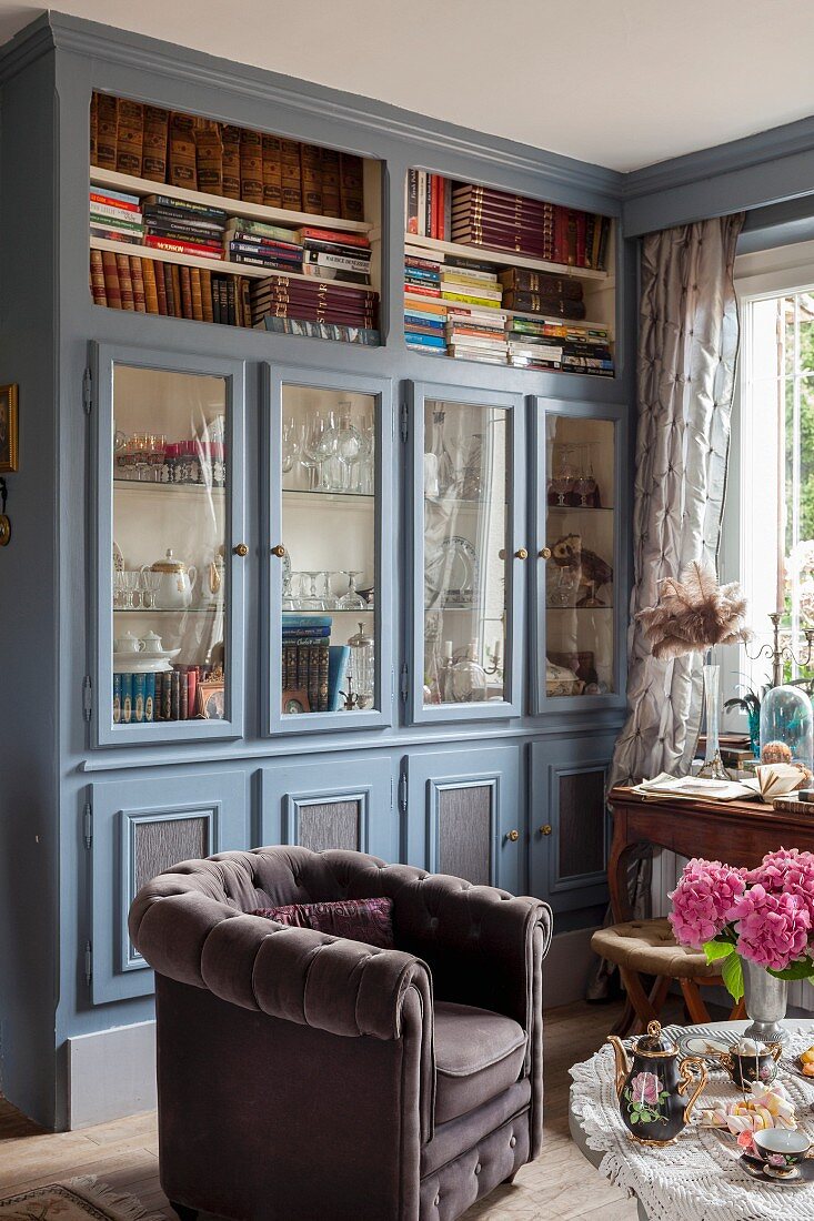Country-house-style, floor-to-ceiling, fitted cabinets with glass doors and open-fronted shelves painted grey and blue